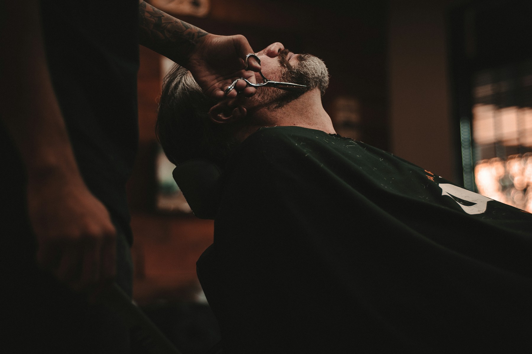 Barber shaping a client's beard